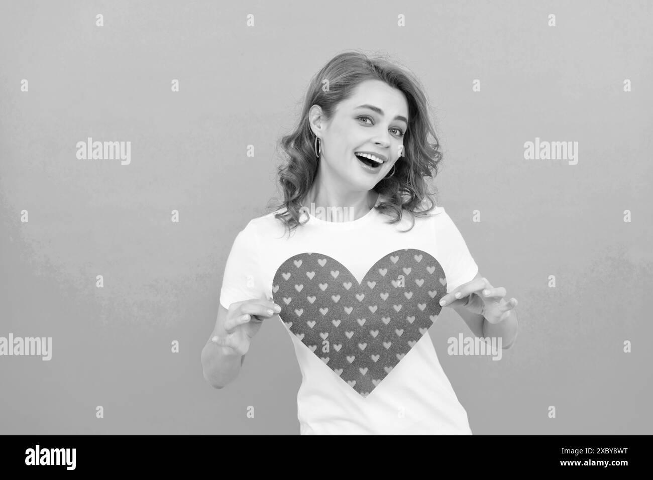 happy redhead fille tenir coeur rouge sur fond bleu Banque D'Images