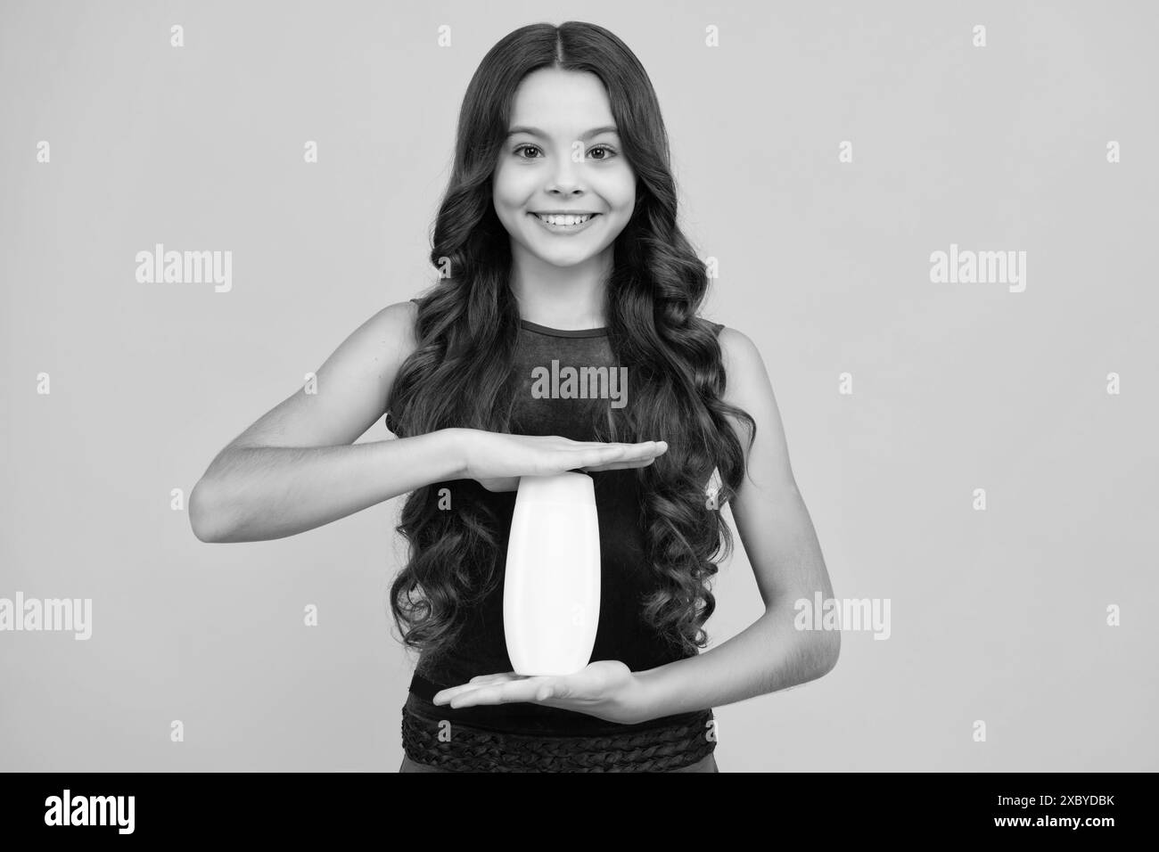 Enfant avec après shampooing. Soins cosmétiques quotidiens. L'adolescent de 12, 13, 14 ans tient une bouteille de soins pour les cheveux et la peau. Beauté santé et cosmétiques Banque D'Images