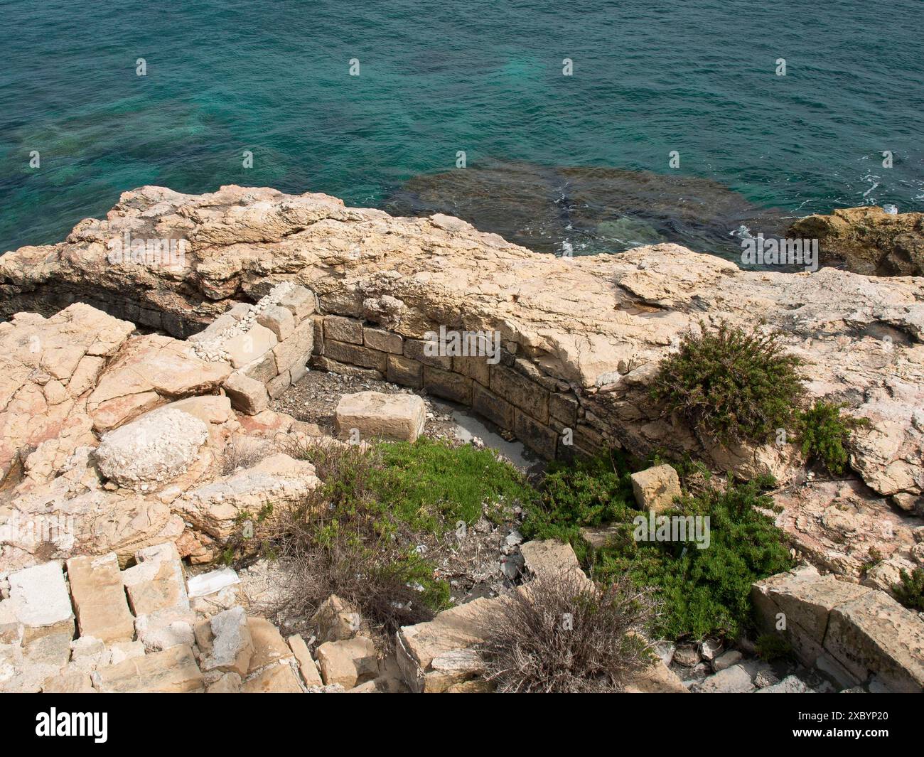 Paysage côtier avec rivage rocheux et eau bleu clair, entouré de formations rocheuses et quelques plantes, valette, mer méditerranée, malte Banque D'Images