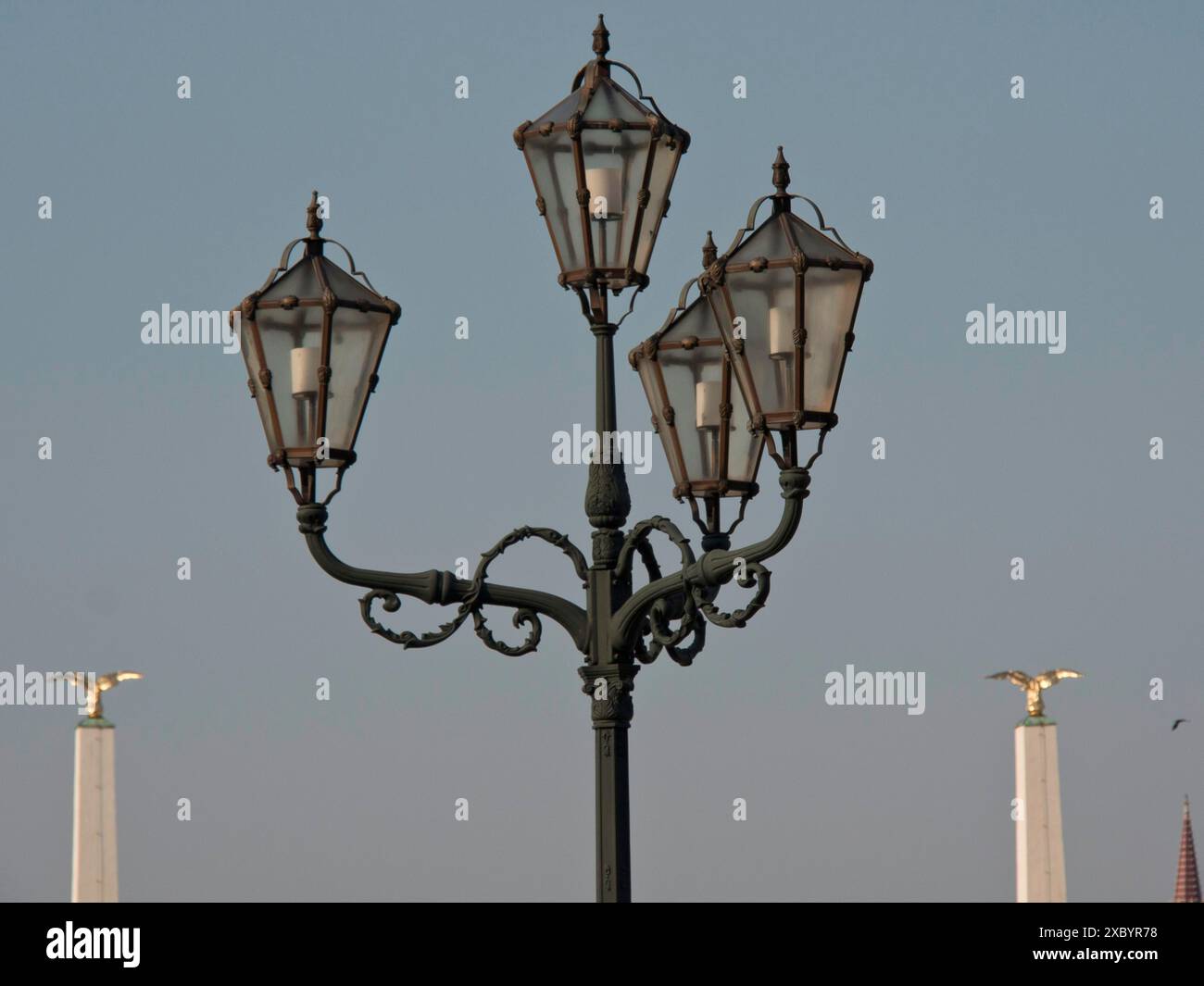 Lampadaire classique avec quatre lumières et éléments décoratifs contre un ciel dégagé, Vienne, Autriche Banque D'Images