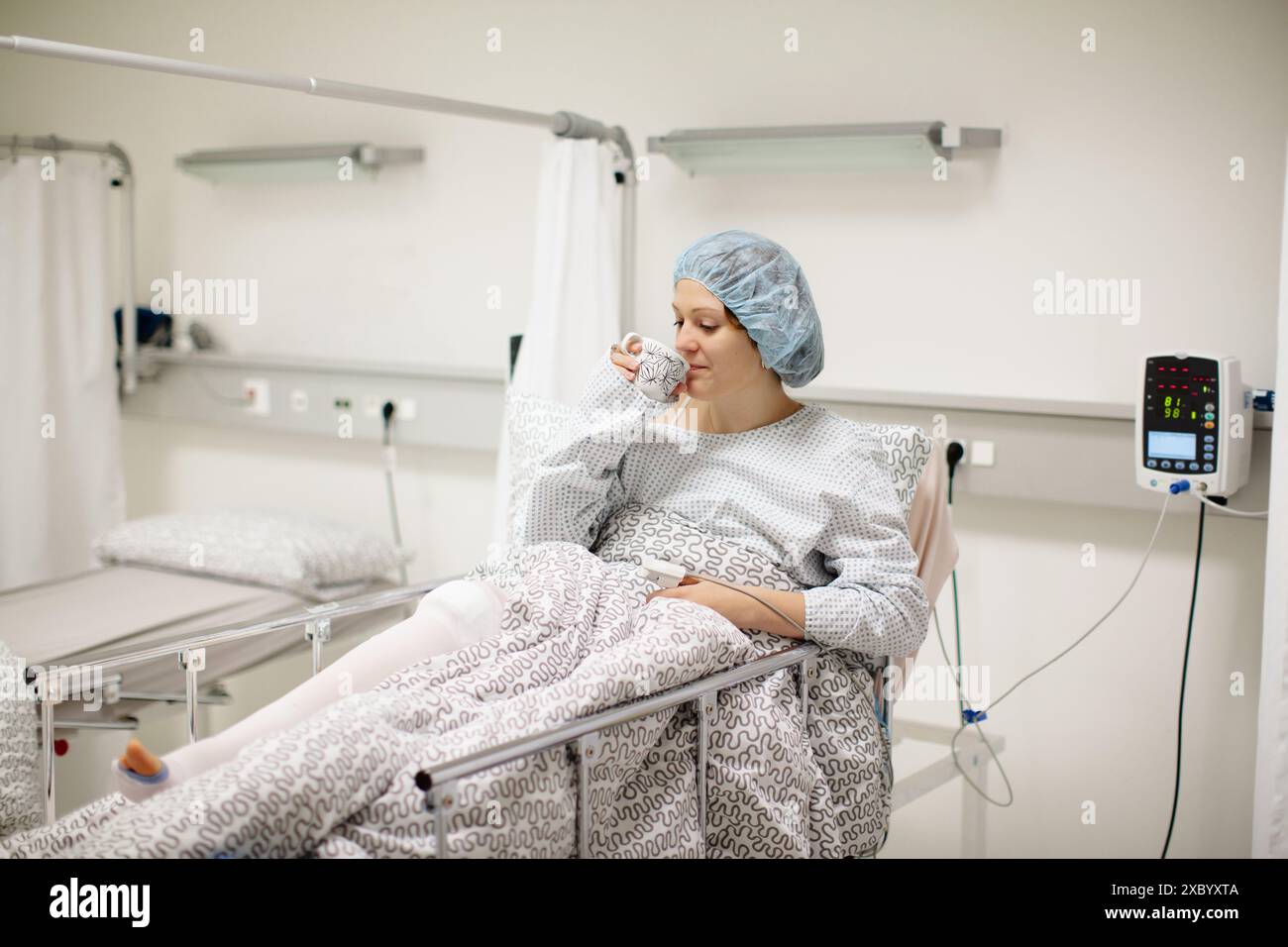 Jeune patient guéri après chirurgie en salle de soins post-opératoires dans un hôpital moderne. Femme avec plâtre et oxymètre de pouls après une opération de traumatisme du genou Banque D'Images