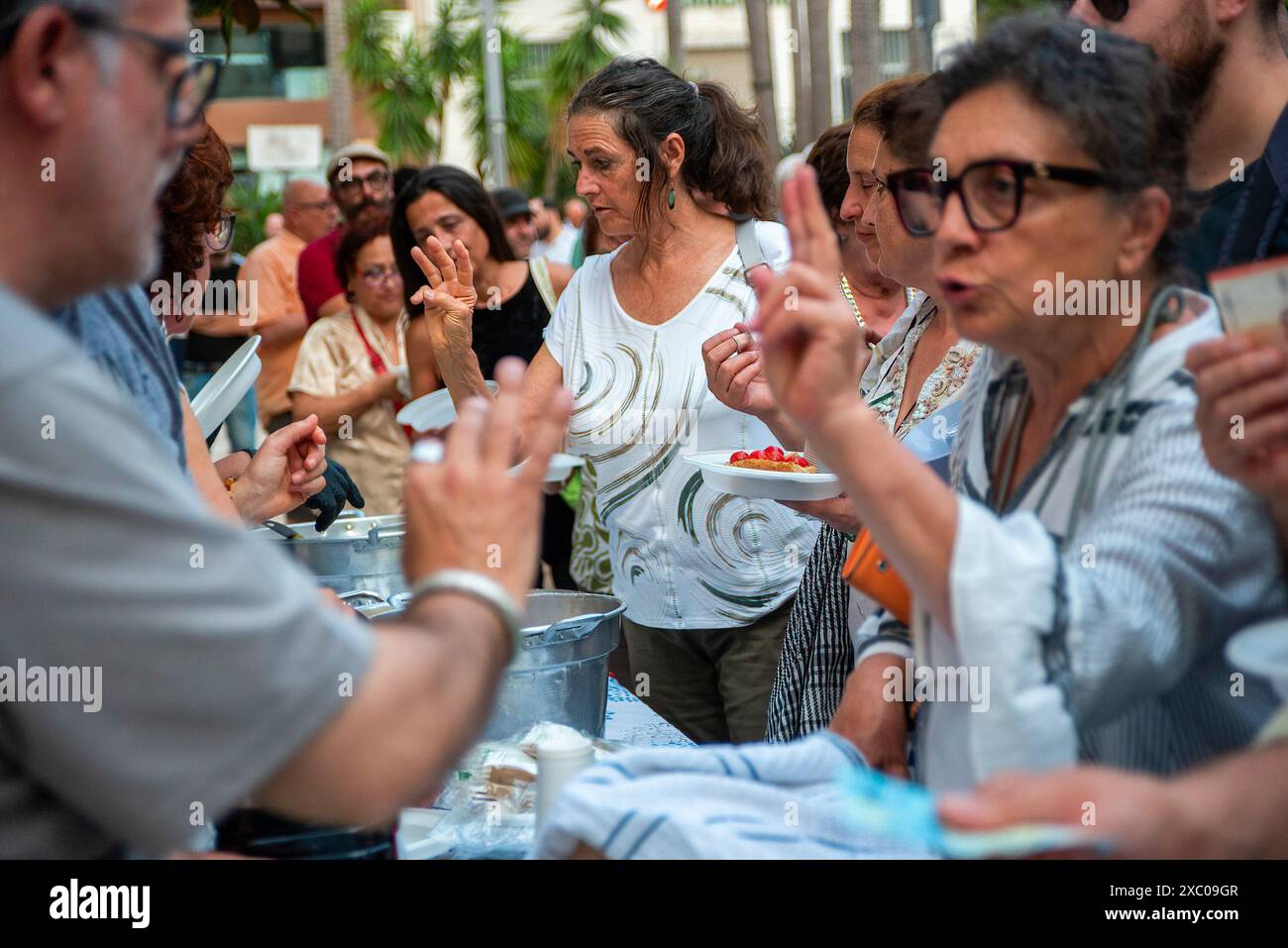 Brindisi, Italie. 13 juin 2024. Les manifestants commandent de la nourriture lors de la manifestation "dîner des pauvres". Le sommet du Groupe des sept (G7) est un forum économique et politique intergouvernemental composé du Japon, de l'Italie, du Canada, du Royaume-Uni, de la France, Allemagne et États-Unis. Cette année, le sommet se tient en Italie. Pendant que le Groupe des sept dînait au château souabe de Brindisi, l'organisation de la société civile a organisé une contre-manifestation intitulée "dîner des pauvres" sur la Piazza Vittoria dans la vieille ville de Brindisi, en Italie. Crédit : SOPA images Limited/Alamy Live News Banque D'Images