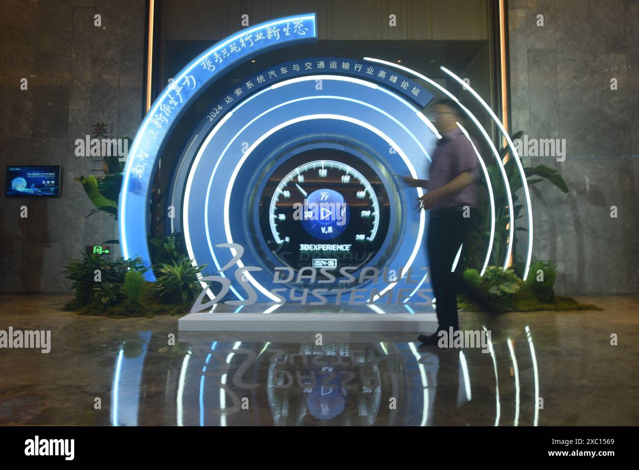 HANGZHOU, CHINE - 14 JUIN 2024 - Un invité passe devant le logo du Forum 2024 de l'industrie automobile et des transports de Dassault systèmes à Han Banque D'Images