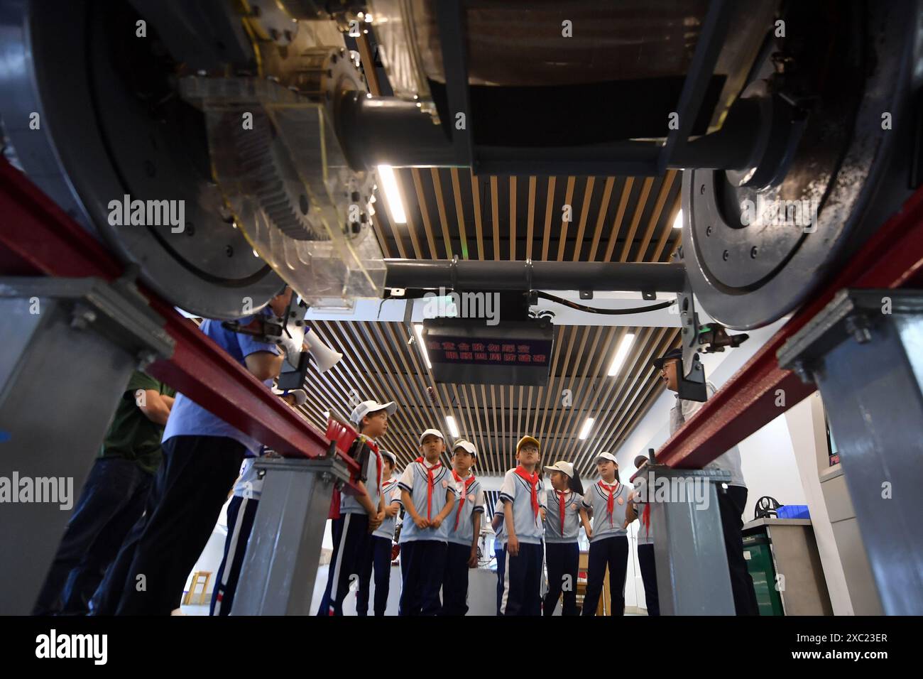 QINGDAO, CHINE - 14 JUIN 2024 - des élèves visitent une expérience de système de freinage de train dans le cadre d'une activité de vulgarisation scientifique et de recherche dans une école primaire Banque D'Images