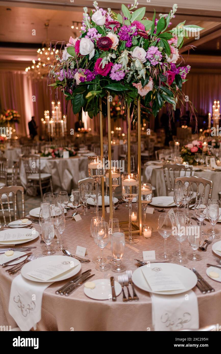 Décoration florale élevée lors d'une réception de mariage éclairée aux chandelles Banque D'Images