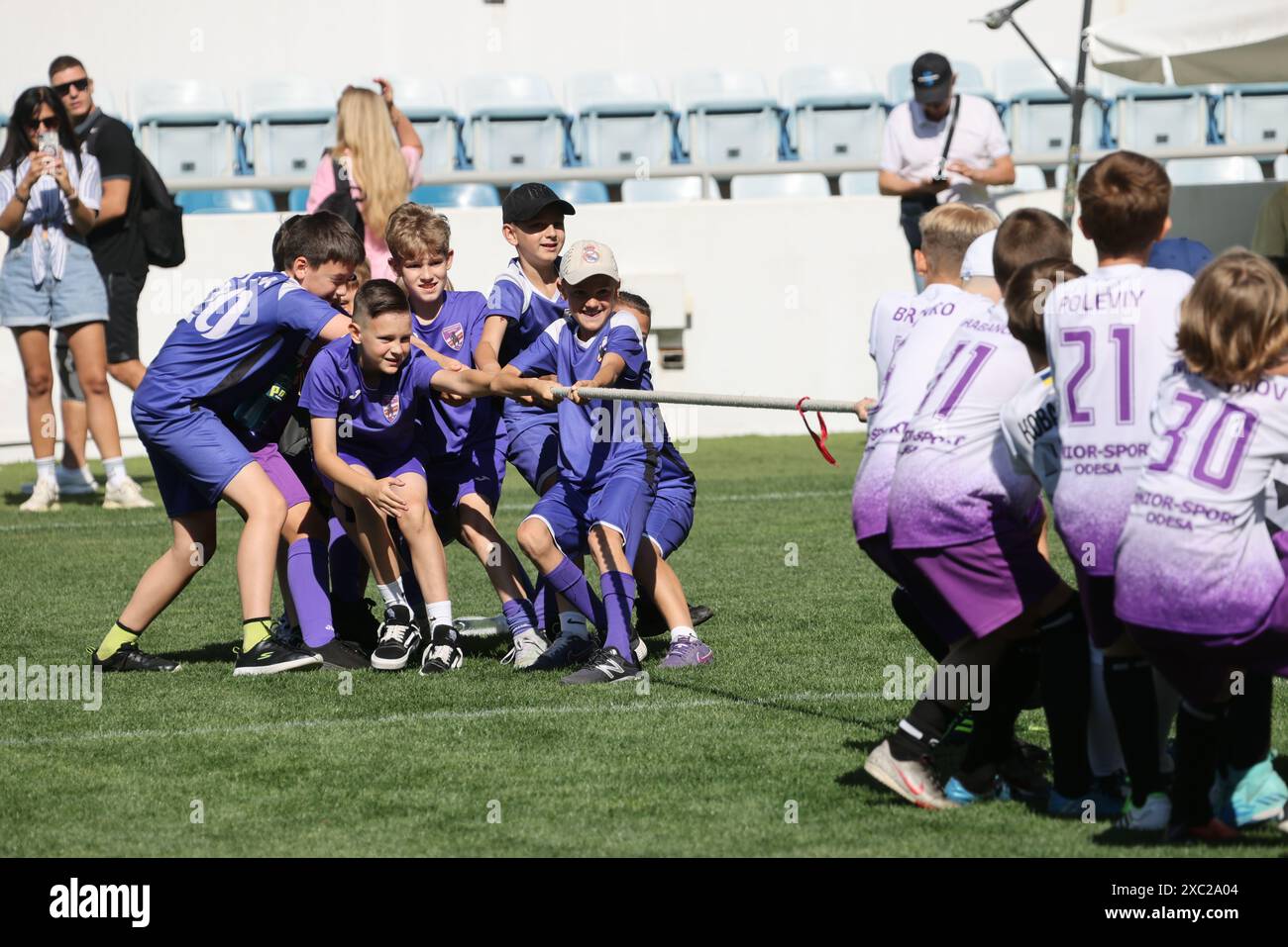 ODESSA, UKRAINE, 9 juin 2024 : des équipes d'enfants jouent à la guerre lors d'un festival sportif. Combat d'équipe sportive - remorqueur de guerre sur l'herbe verte de la pelouse du stade. Chi Banque D'Images