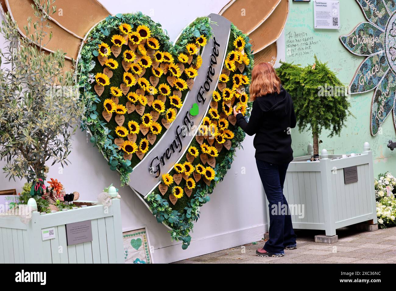 Londres, Royaume-Uni. 14 juin 2024. Touche finale à un nouvel hommage floral. L'incendie de la tour Grenfell s'est produit il y a exactement 7 ans aujourd'hui. Les gens rendent hommage et laissent des hommages floraux. Ce soir, il y aura une marche silencieuse pour commémorer ceux qui sont morts dans l'incendie. Crédit : Mark Thomas/Alamy Live News Banque D'Images