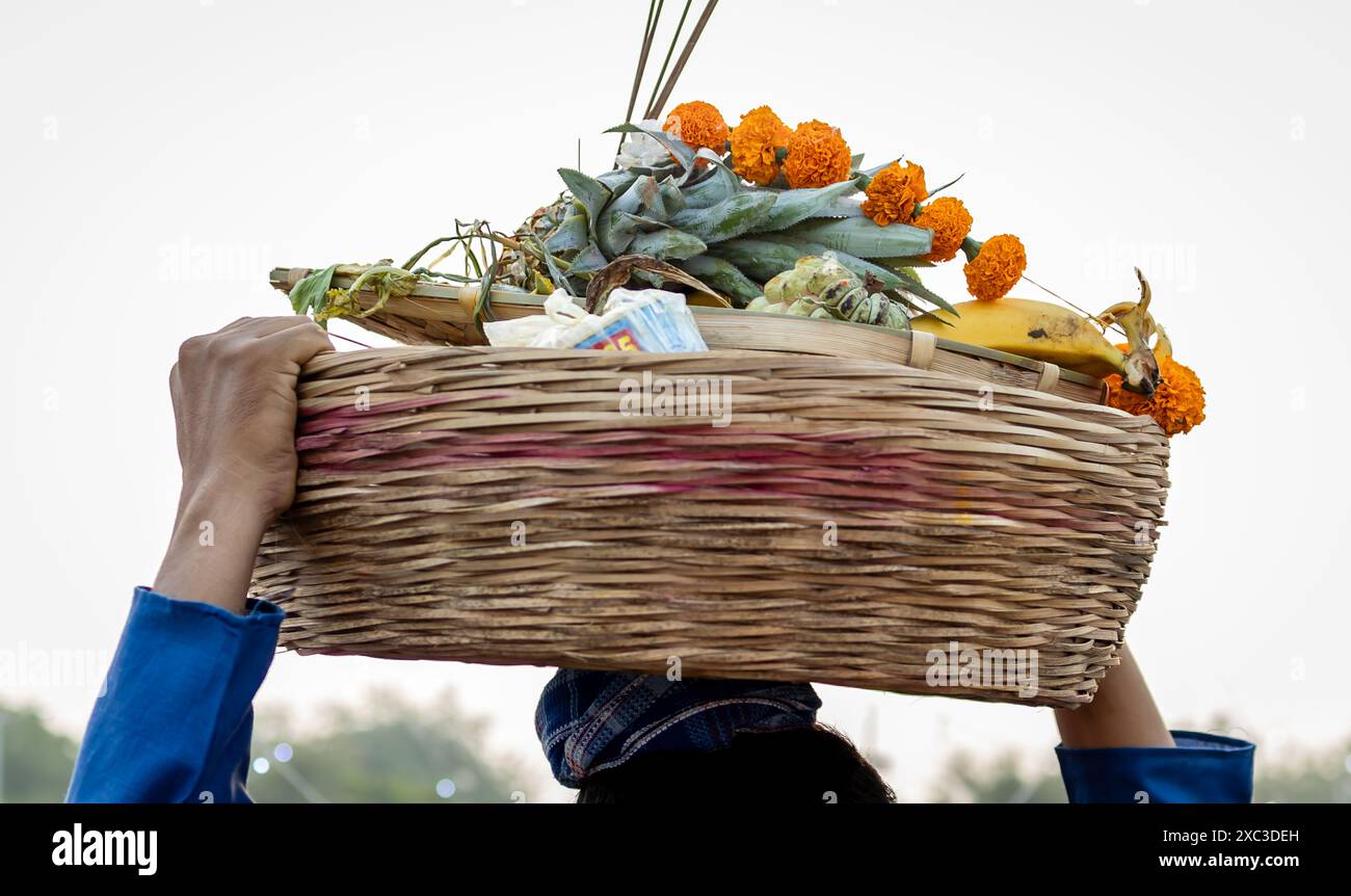 les gens portant l'offrande sainte à la tête à l'occasion de la fête de chhath en inde Banque D'Images