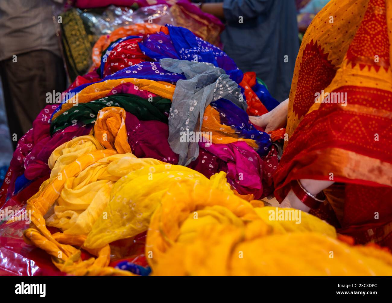 détaillants vêtir le vendeur montrant différents types de saree de robe traditionnelle indienne au client à la boutique Banque D'Images