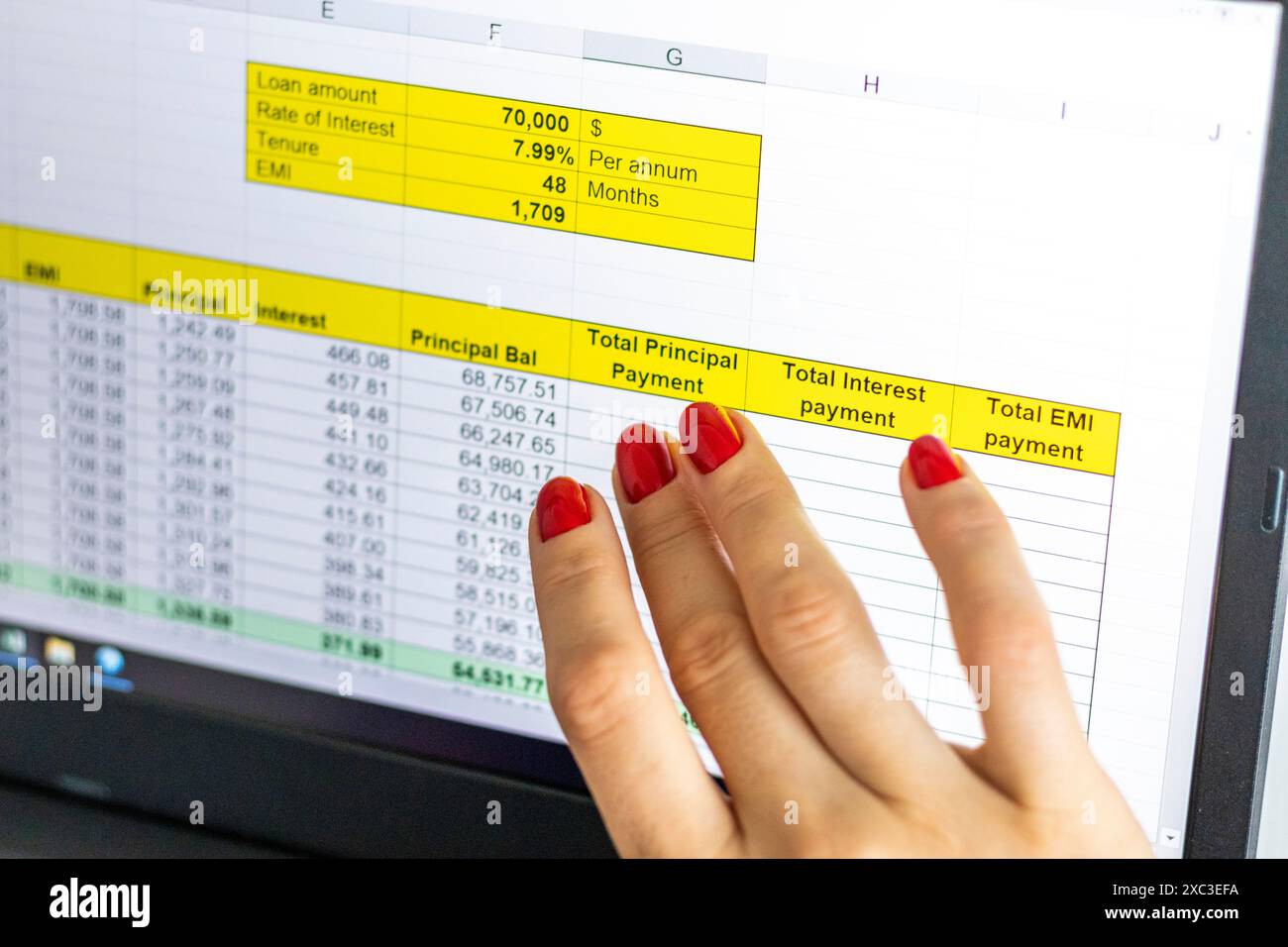 Gros plan de la femme avec de belles mains et manucure, travaillant sur l'ordinateur portable, écran tactile défilant avec table d'amortissement de prêt hypothécaire ouverte Banque D'Images