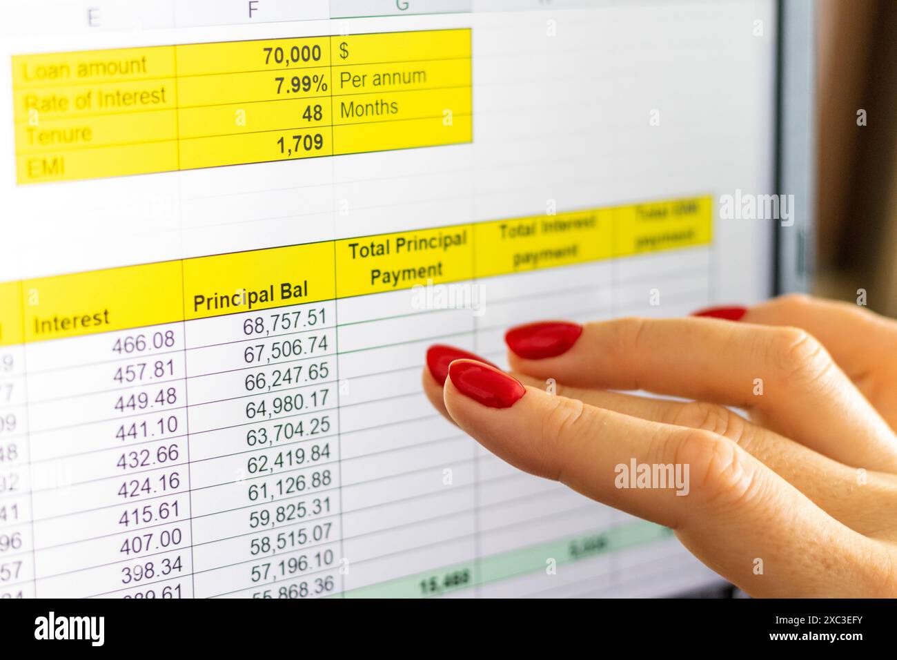 Gros plan de la femme avec de belles mains et manucure, travaillant sur l'ordinateur portable, écran tactile défilant avec table d'amortissement de prêt hypothécaire ouverte Banque D'Images