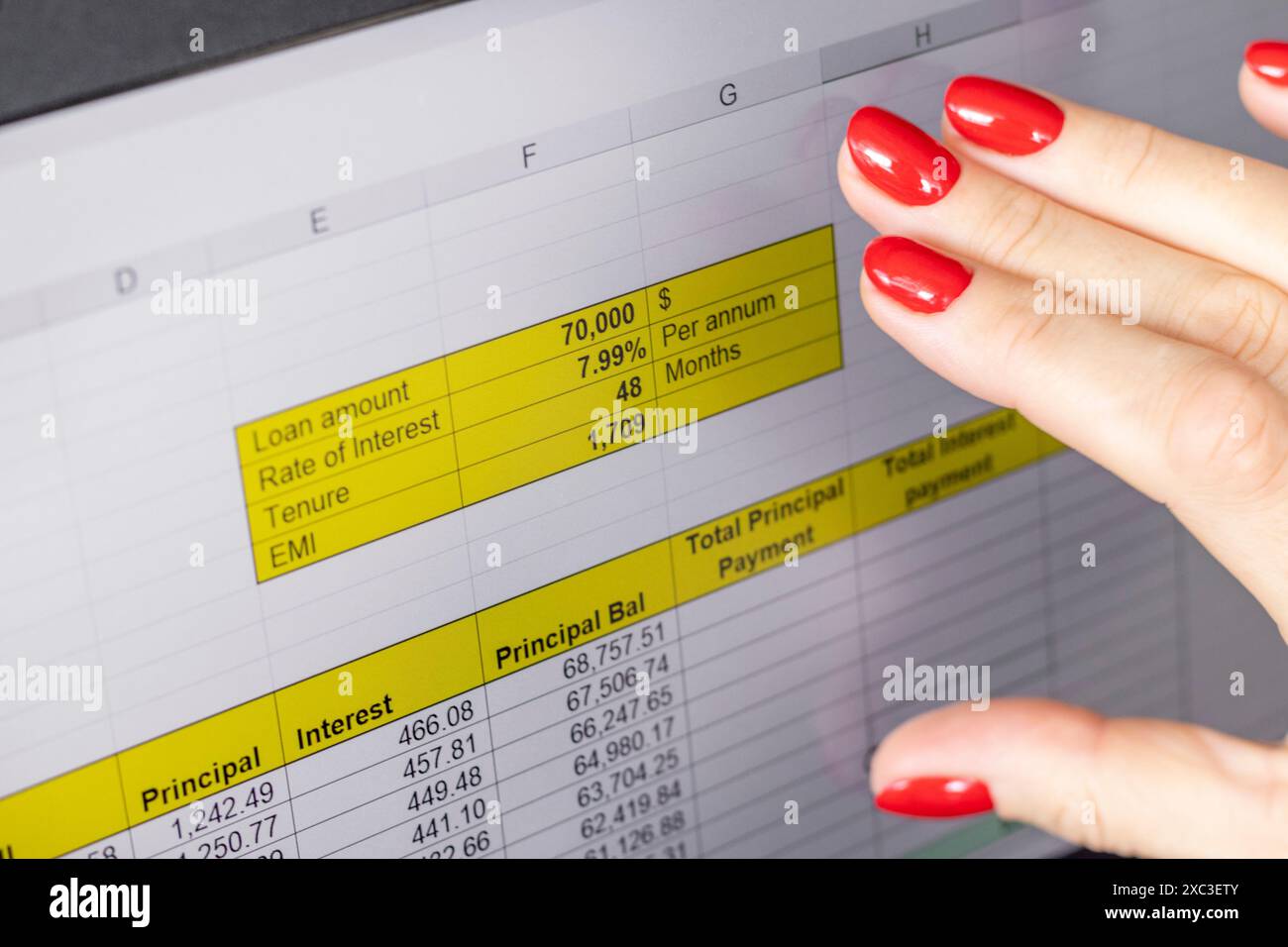 Gros plan de la femme avec de belles mains et manucure, travaillant sur l'ordinateur portable, écran tactile défilant avec table d'amortissement de prêt hypothécaire ouverte Banque D'Images