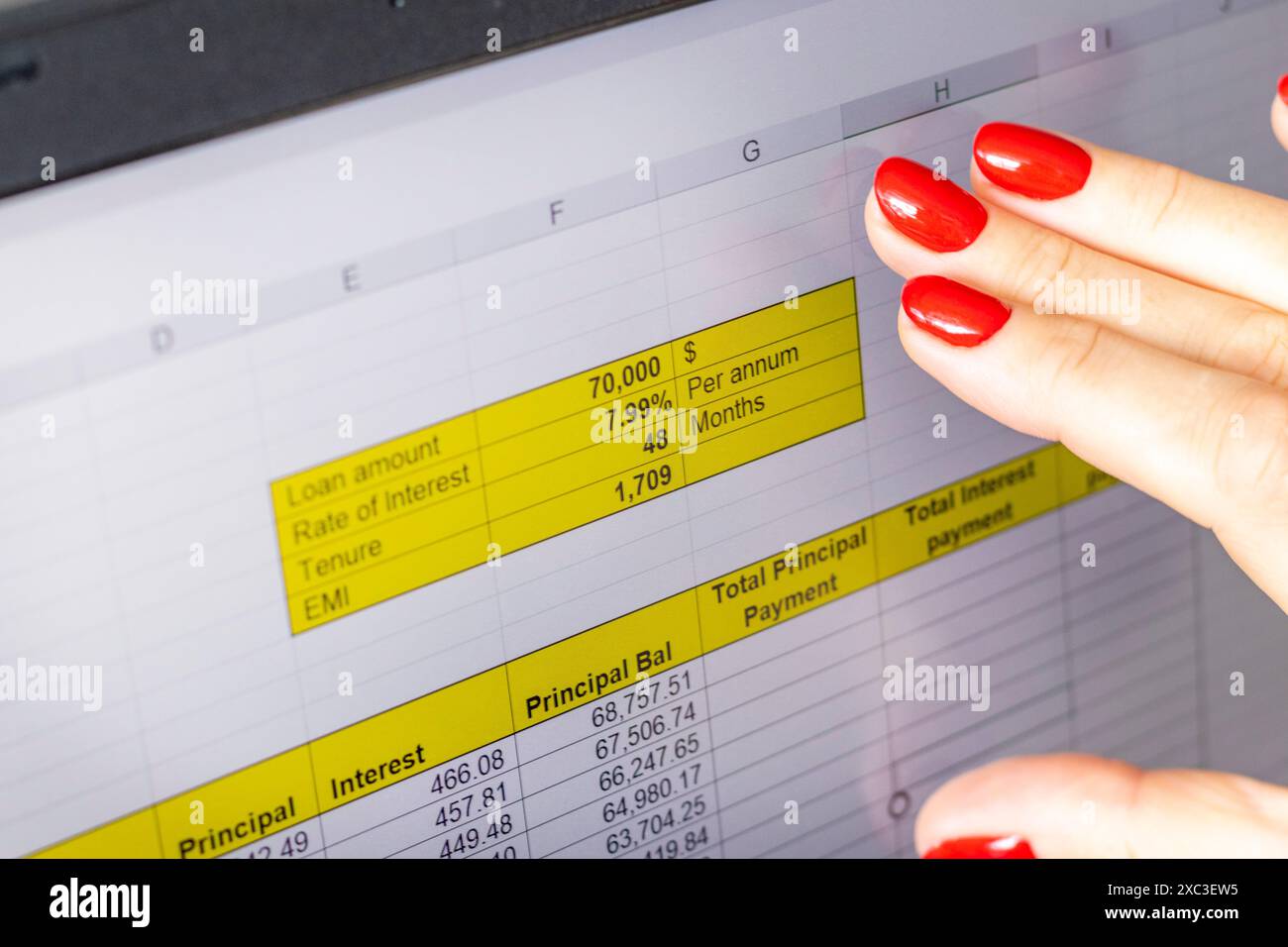 Gros plan de la femme avec de belles mains et manucure, travaillant sur l'ordinateur portable, écran tactile défilant avec table d'amortissement de prêt hypothécaire ouverte Banque D'Images