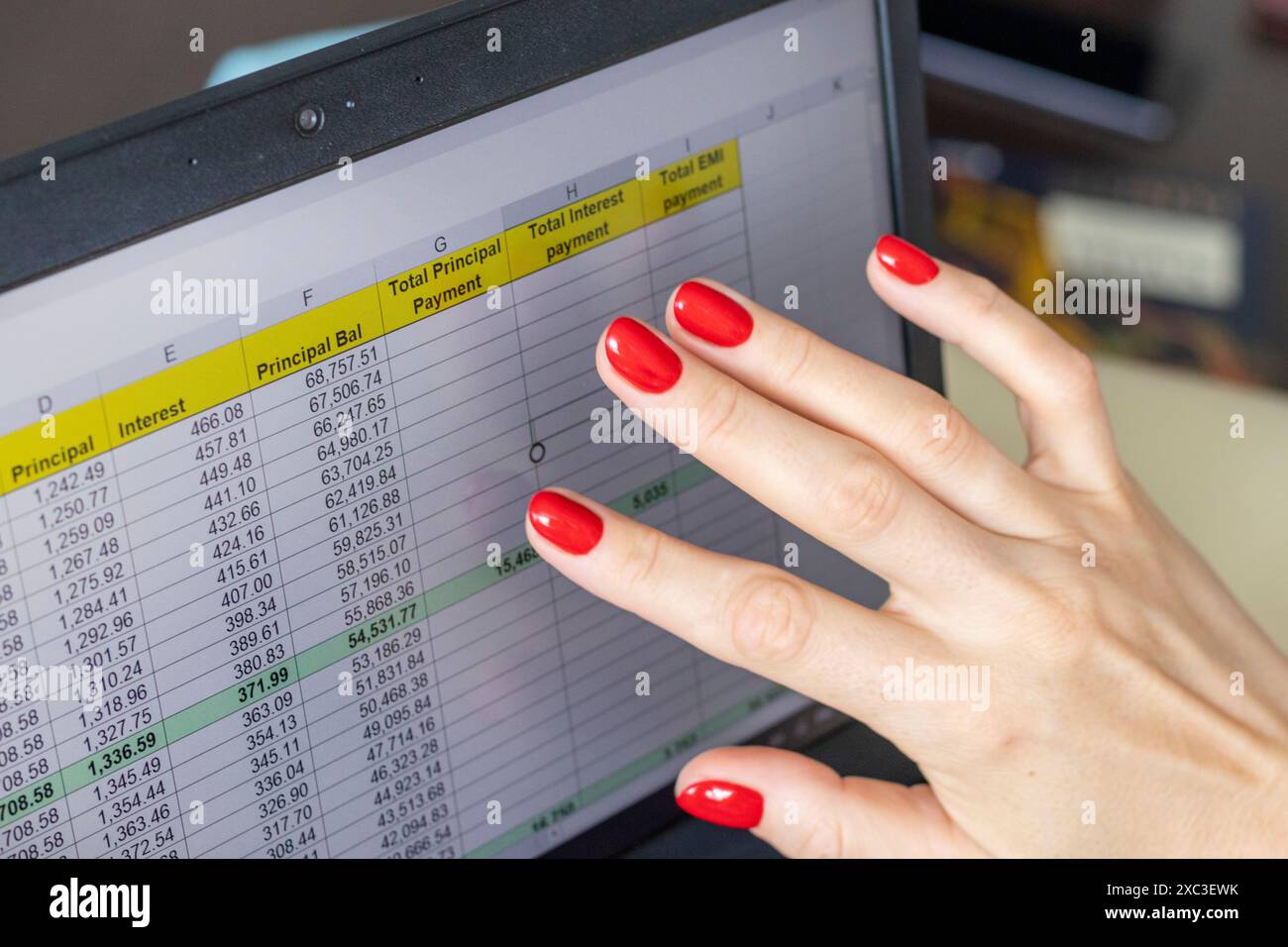 Gros plan de la femme avec de belles mains et manucure, travaillant sur l'ordinateur portable, écran tactile défilant avec table d'amortissement de prêt hypothécaire ouverte Banque D'Images