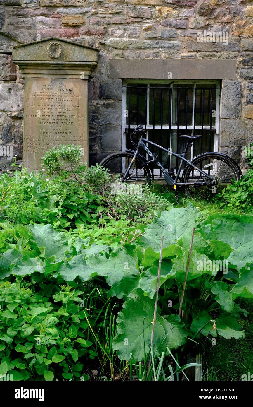 Un parking à vélos à côté d'une ancienne pierre tombale à l'extérieur de la maison d'un gardien dans Greyfriars Kirkyard.Edinburgh.Scotland.Royaume-Uni Banque D'Images