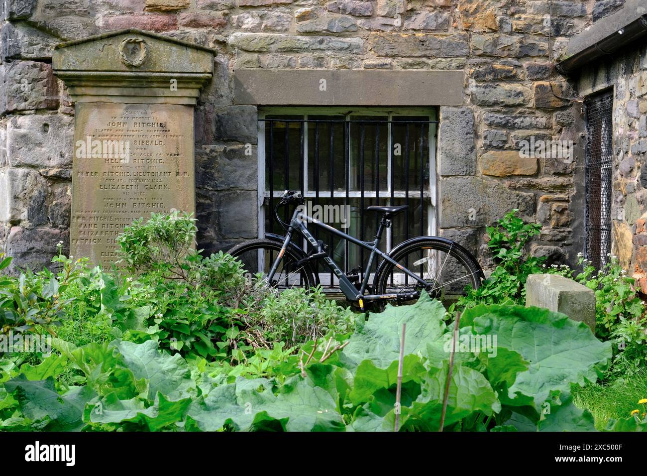 Un parking à vélos à côté d'une ancienne pierre tombale à l'extérieur de la maison d'un gardien dans Greyfriars Kirkyard.Edinburgh.Scotland.Royaume-Uni Banque D'Images