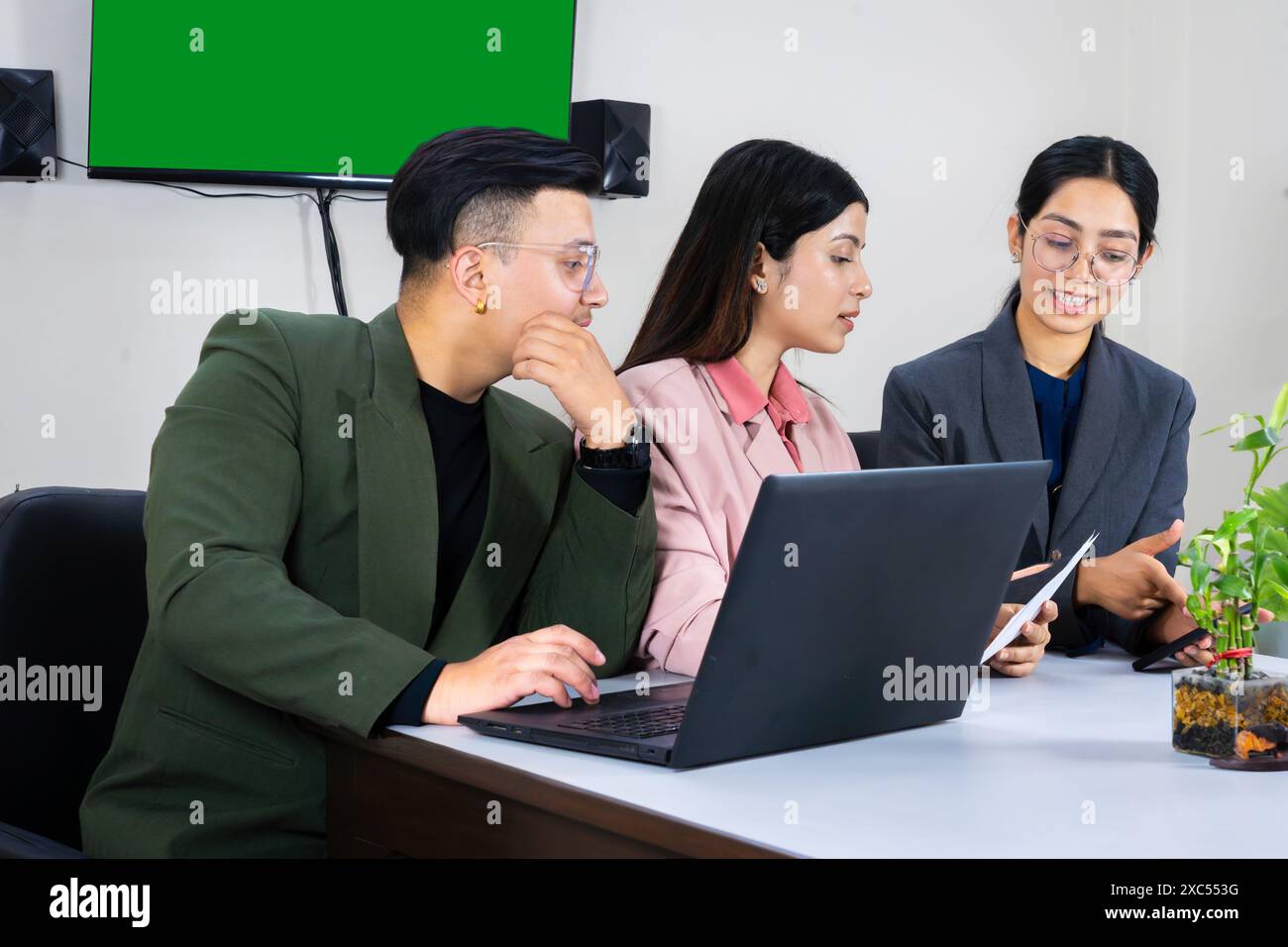 une équipe de bureau d'homme et de femme d'affaires devant un écran vert dans une table de réunion discutant Banque D'Images