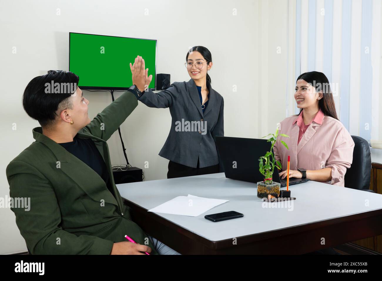 une équipe de bureau d'homme et de femme d'affaires devant un écran vert dans une table de réunion discutant Banque D'Images