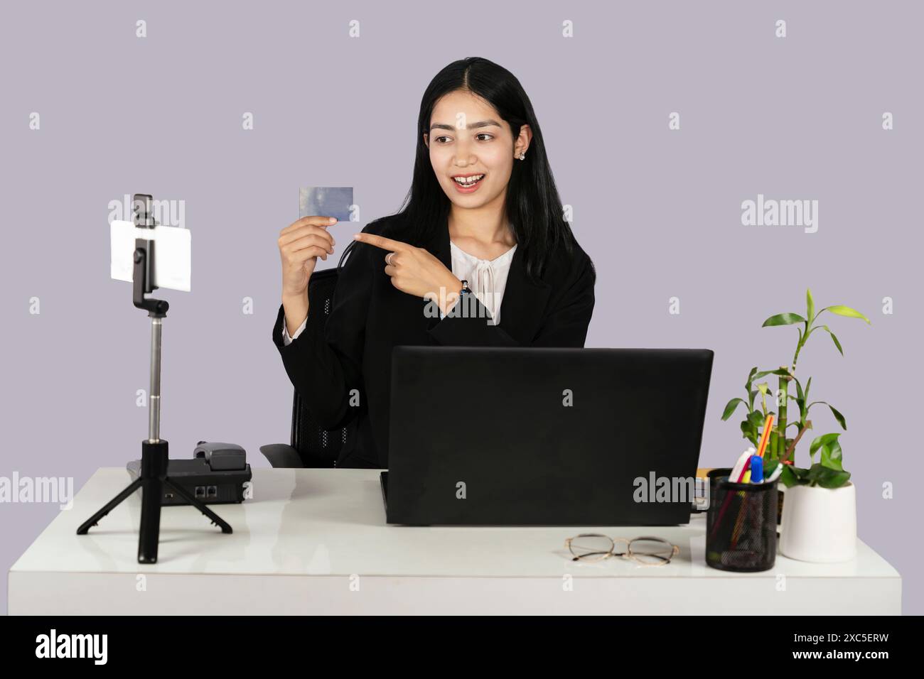 Belle femme d'affaires à la réception montre une maquette de carte de visite Banque D'Images