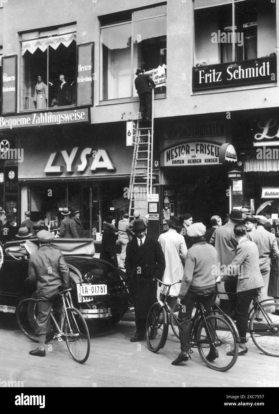Un homme collant une affiche antisémite lors du boycott des entreprises juives le 1er avril 1933. Le boycott des entreprises juives a été la première action directe anti-juive qui a conduit à l'exclusion des Juifs de la société et finalement à l'extermination, et il a eu lieu seulement deux mois après l'arrivée d'Hitler au pouvoir. Banque D'Images