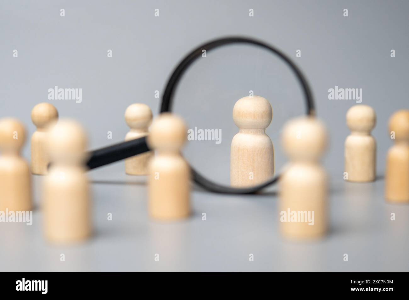 Poupées en bois et loupe. Concept d'acquisition, de recrutement et d'embauche de talents. Banque D'Images