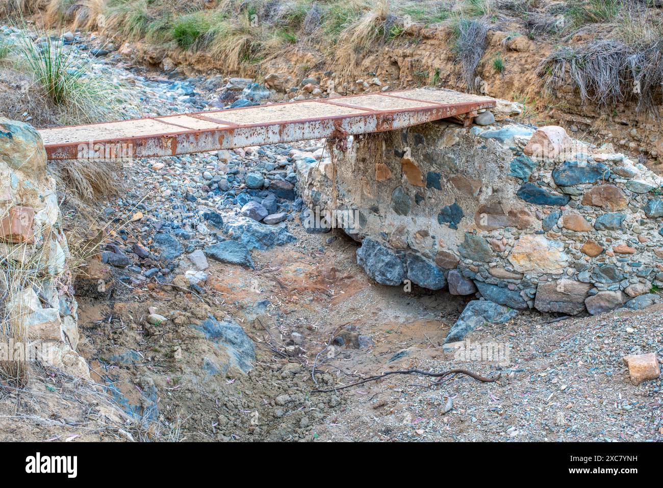 Pont rustique en béton traversant un lit de ruisseau sec. Situé à Arroyo Seco, Villaviciosa de Córdoba, Andalucía, España. Banque D'Images