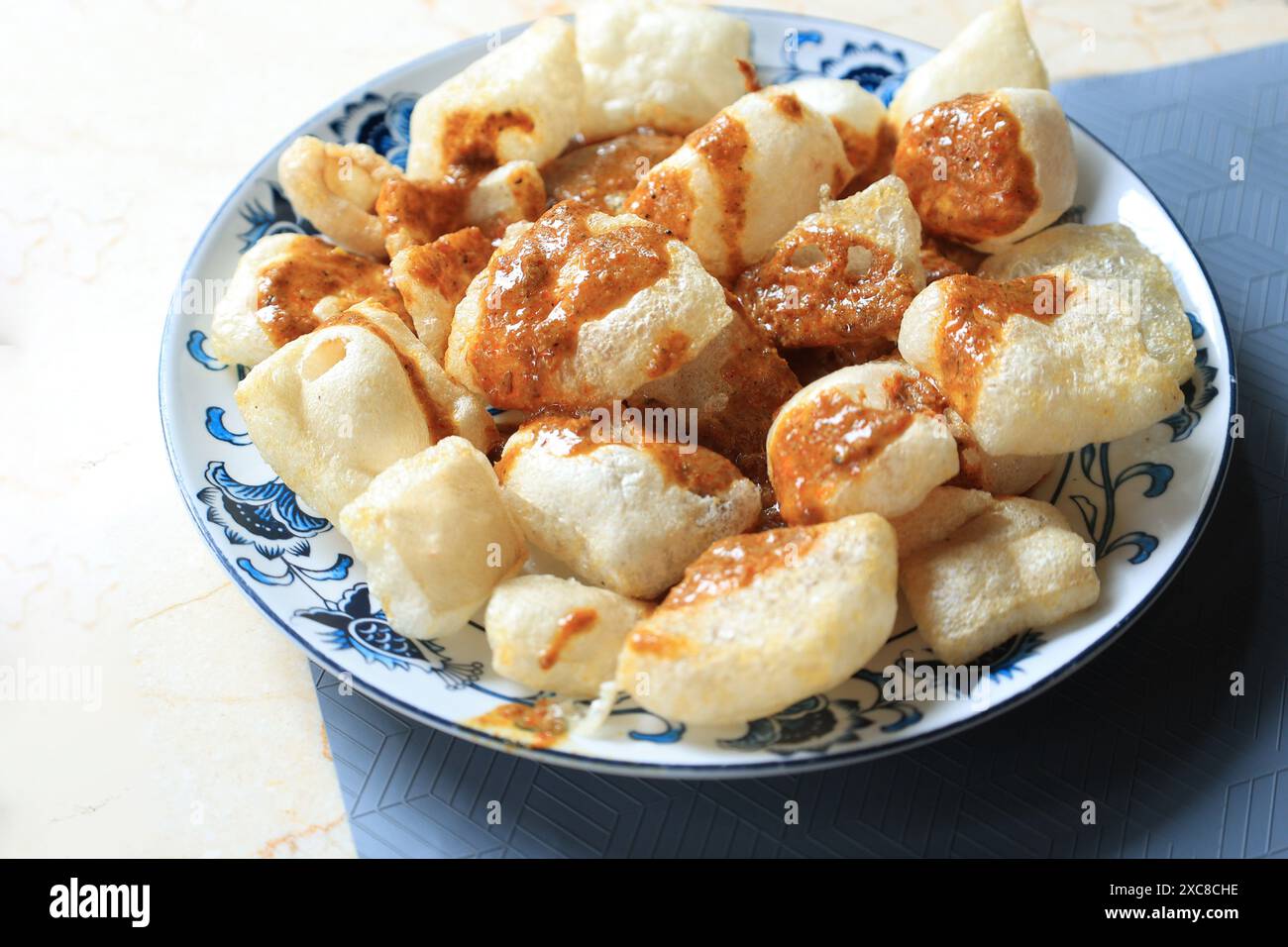 Kerupuk Rambak, crackers à base de peau de vache. Jangek Karupuak en sauce curry. Plat traditionnel Chips de Palembang et Padang, Sumatera, Indonésie Banque D'Images