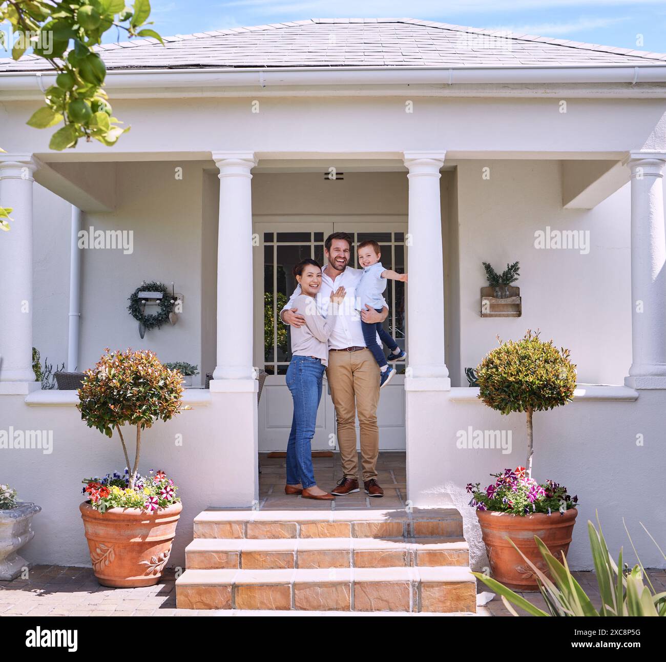 Heureux, portrait et famille en plein air de la nouvelle maison avec câlin, amour et soin pour l'hypothèque ensemble. Sourire, porche et parents embrassant et liant avec le garçon Banque D'Images