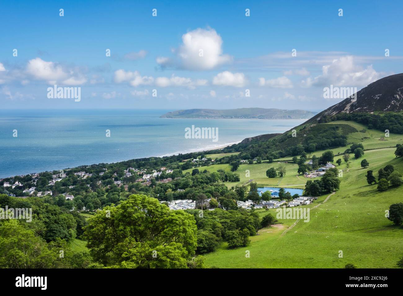 Vue élevée sur le village en dessous de Foel lus sur la côte pittoresque avec Great Orme au loin. Penmaenmawr, Conwy, nord du pays de Galles, Royaume-Uni, Grande-Bretagne Banque D'Images