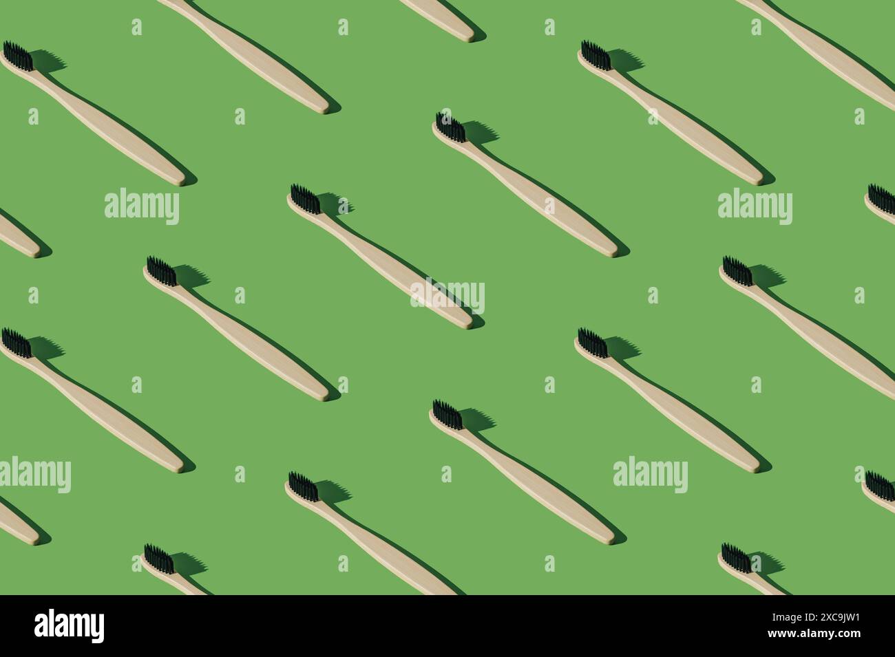 Composition de motif de brosse à dents en bambou organique sur fond vert. Concept dentaire minimal. Modèle créatif de brosse à dents écologique et biodégradable. Banque D'Images