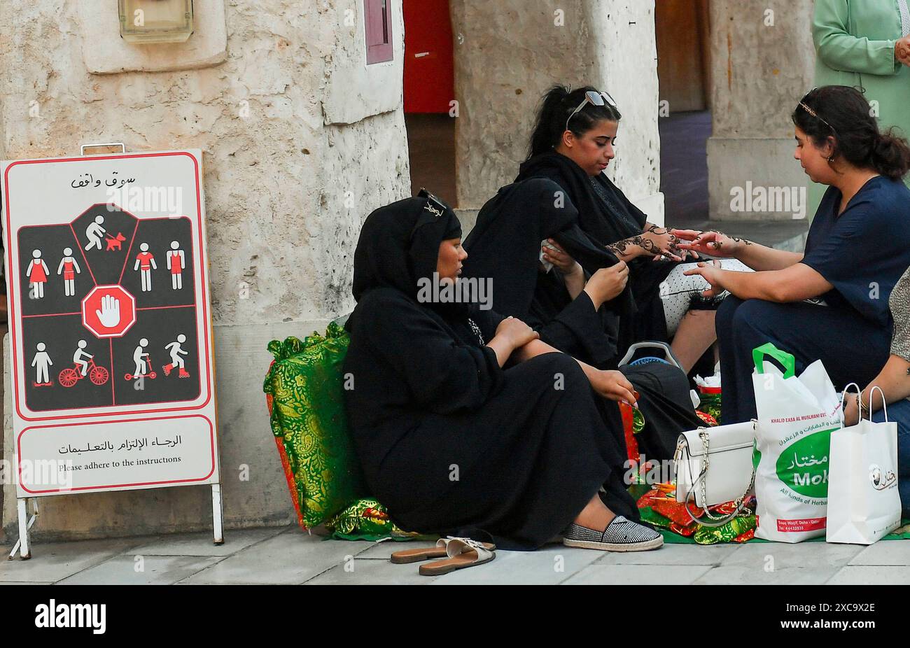 QATAR SHOPPING Eid Al-Adha PRÉPARATION 2024 les femmes appliquent un design traditionnel au henné sur leurs mains au marché traditionnel du Souq Waqif avant le prochain Aid al-Adha à Doha, Qatar, le 15 juin 2024. Les musulmans du Qatar célébreront l’Aïd al-Adha le 16 juin 2024, la Fête du sacrifice, qui marque la fin du pèlerinage du Hadj à la Mecque et commémore la volonté du prophète IbrahamÕs de sacrifier son fils pour montrer son obéissance à Dieu. DOHA Qatar Copyright : xNOUSHADx Banque D'Images