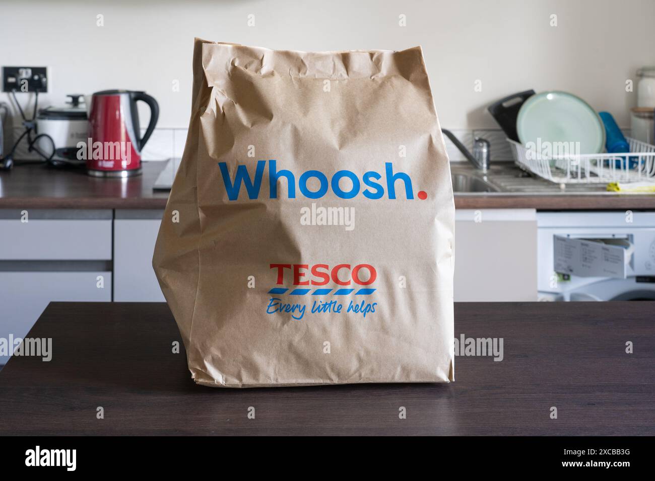 Sac en papier whoosh plein de produits d'épicerie sur un comptoir de cuisine à domicile - une marque de supermarché Tesco pour la livraison à domicile le jour même de Tesco Express. Angleterre Banque D'Images