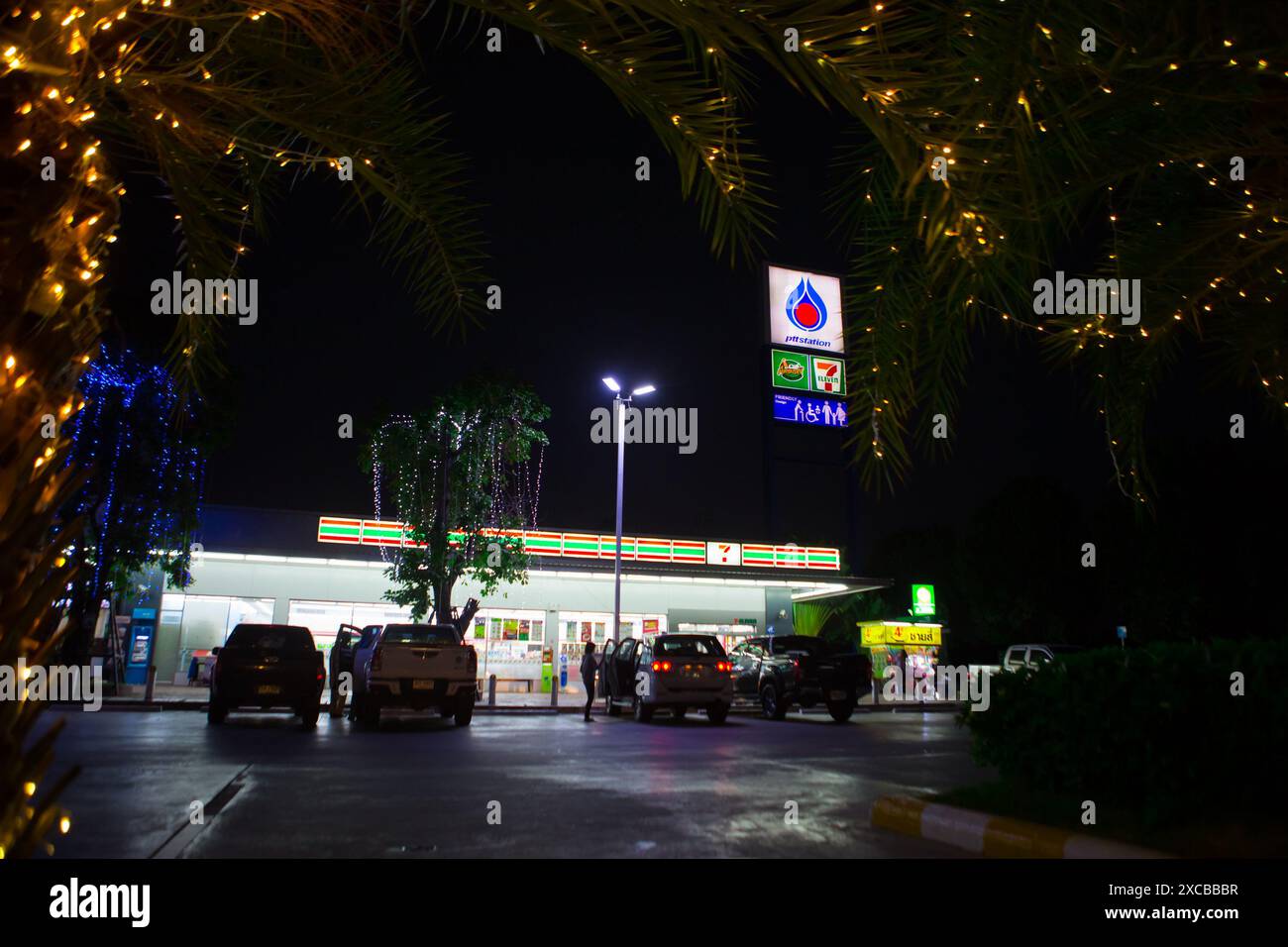 Mahasakham, Thaïlande - 30 novembre 2021 : station d'essence PTT. Il est décoré avec de belles lumières lorsque le soleil se couche. Banque D'Images