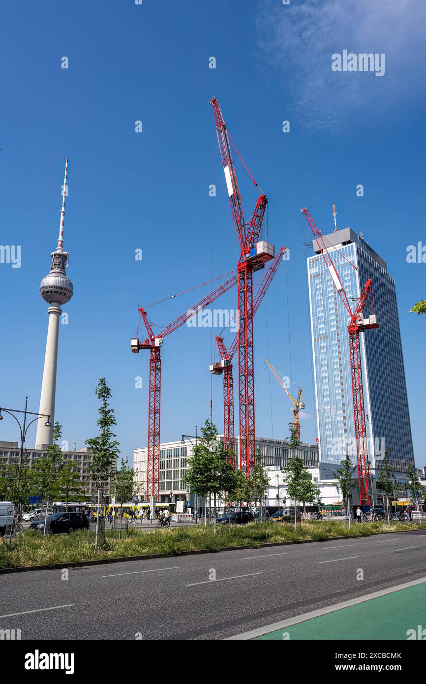 La célèbre Alexanderplatz à Berlin avec la tour de télévision et quatre grues de construction rouges Banque D'Images