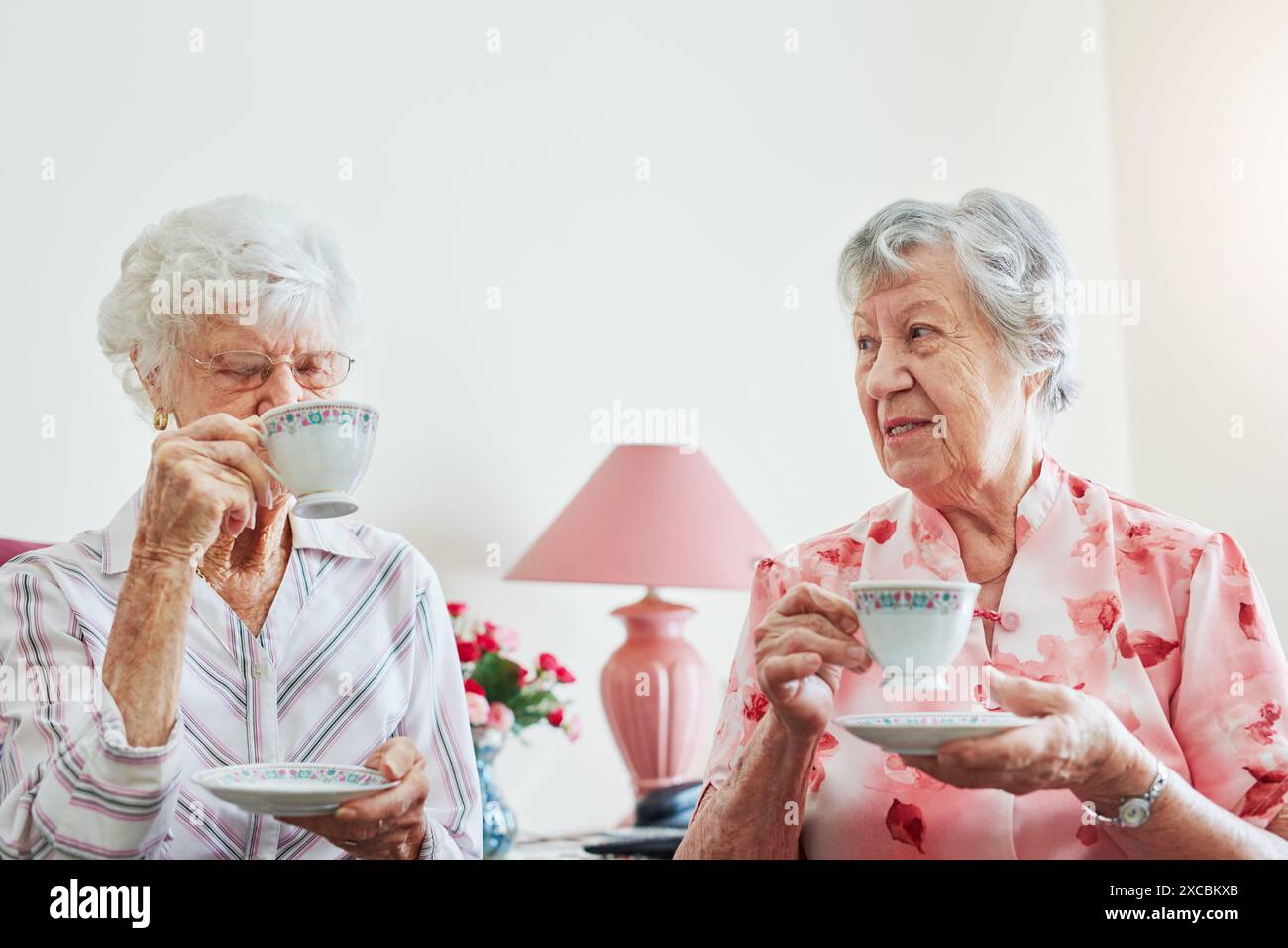Femmes âgées, amis et thé dans le salon avec sourire en portrait pour les soins, l'amour ou le lien avec les retrouvailles. Personnes âgées, à l'écoute et café pour Banque D'Images