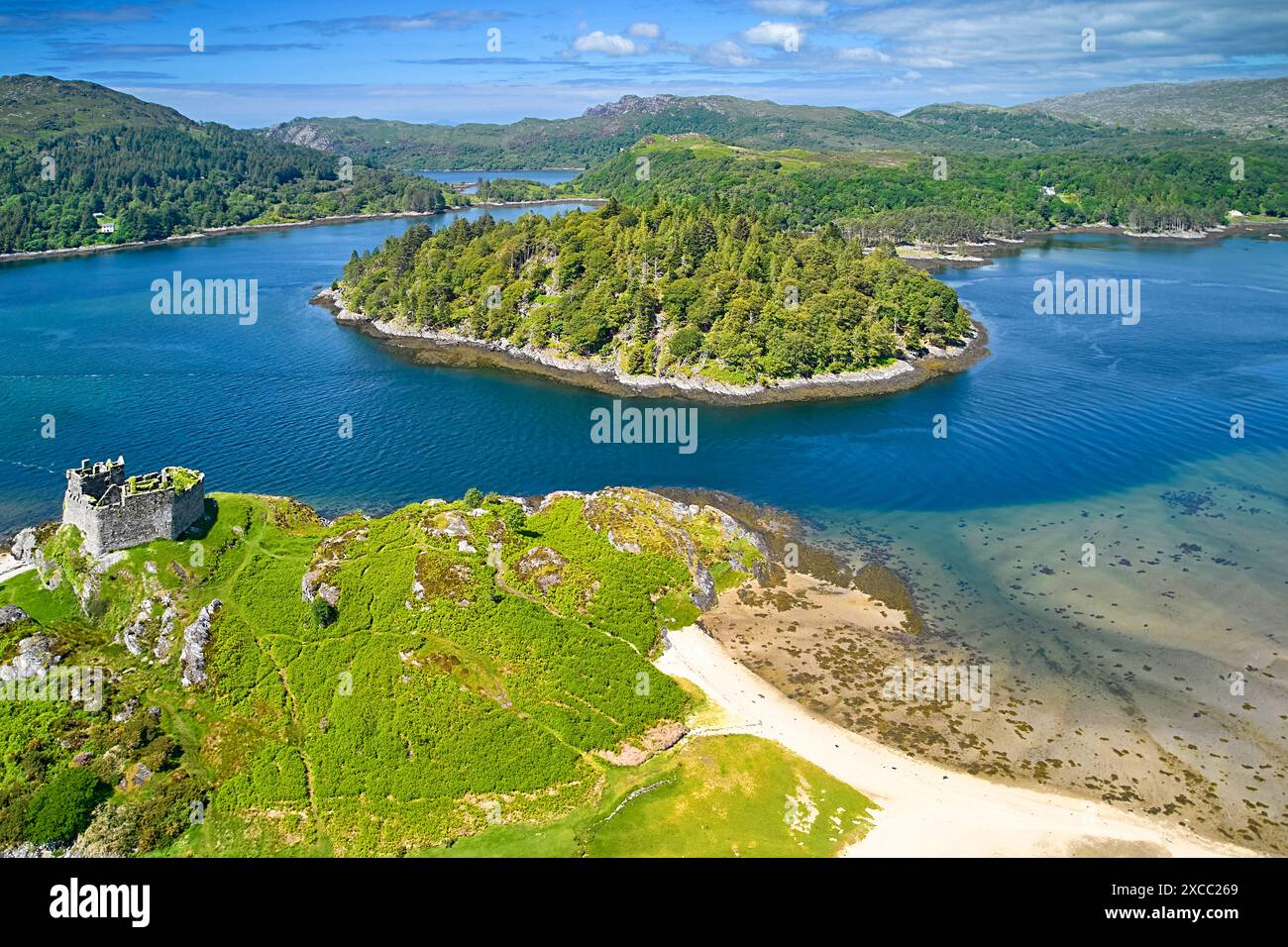 Ruines du château de Tioram sur l'île d'Eilean Tioram dans le Loch Moidart en Écosse et l'île de Riska dans le centre Banque D'Images