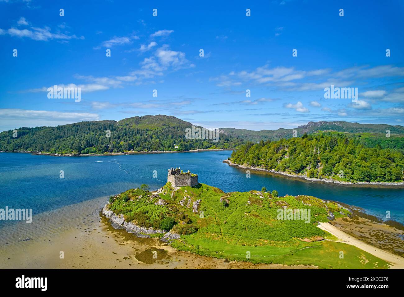 Château de Tioram les ruines de l'île d'Eilean Tioram dans le Loch Moidart en Écosse et l'île de Riska recouverte d'arbres Banque D'Images