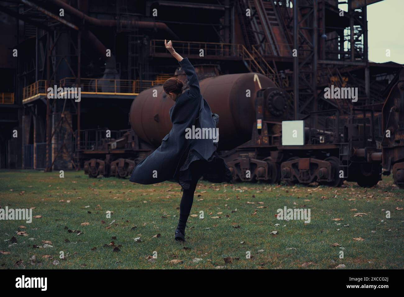 Ballerine sur fond d'une énorme usine abandonnée Banque D'Images