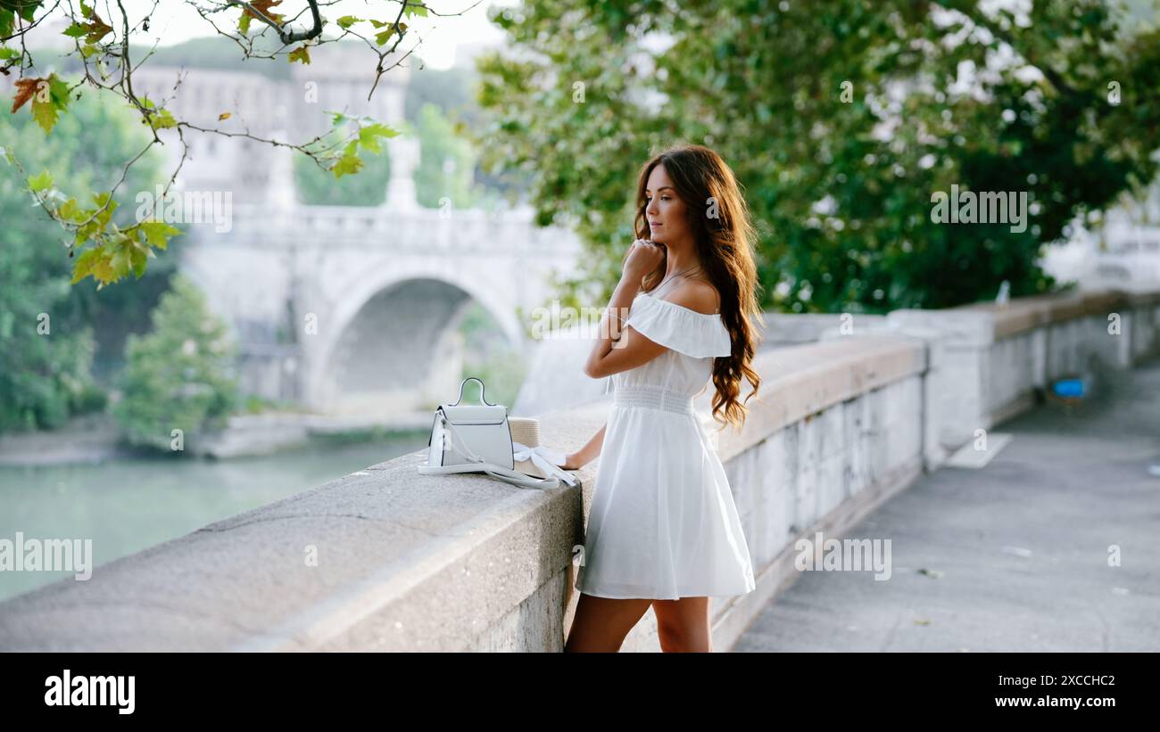 Rome, Italie. Fille en blanc pose sur la toile de fond d'un pont sous un bel arbre Banque D'Images