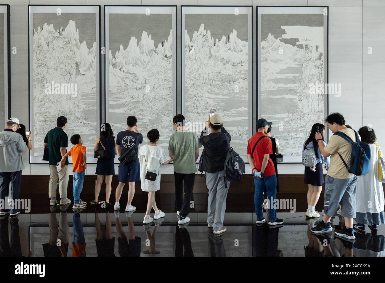 Shanghai, Chine. 16 juin 2024. Les gens regardent des œuvres d'art aux grands Halls de Shanghai, dans l'est de la Chine, le 16 juin 2024. La première journée portes ouvertes publique des grands Halls a été lancée dimanche à Shanghai, attirant de nombreux visiteurs. Composé de trois vieux bâtiments d'une superficie de 99 000 mètres carrés, les grandes salles étaient auparavant le quai du fleuve Yangtsé avec une histoire de plus de 100 ans. Crédit : Wang Xiang/Xinhua/Alamy Live News Banque D'Images