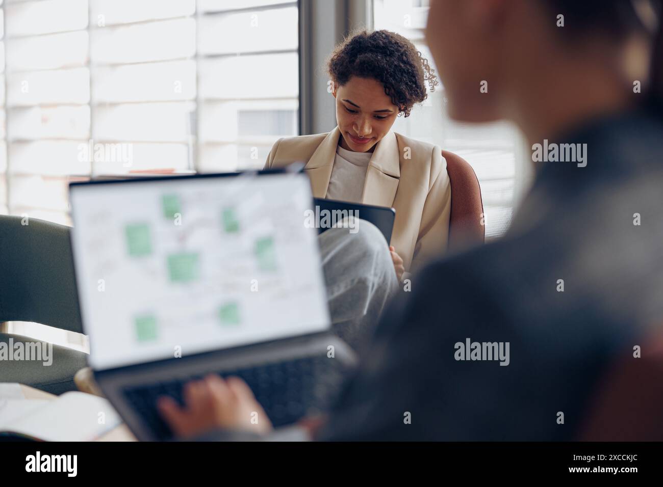 Les jeunes femmes d'affaires concentrées utilisent des gadgets tout en travaillant dans le coworking. Concept de travail à distance Banque D'Images
