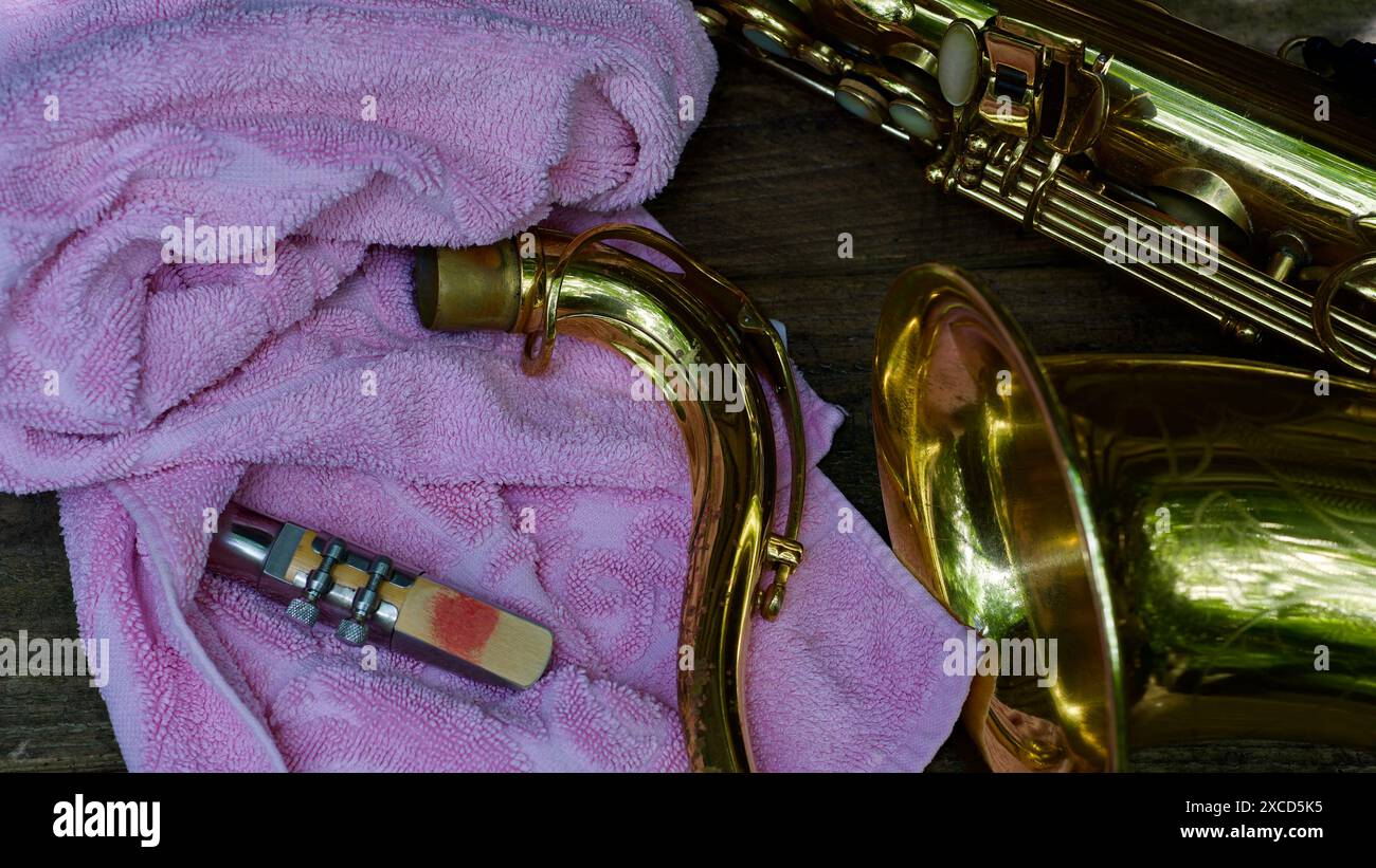 Un saxophone ténor, un cou, un embout buccal, une serviette. Un embout buccal sanglant causé par un jeu trop dur. Concept embouchure. Banque D'Images