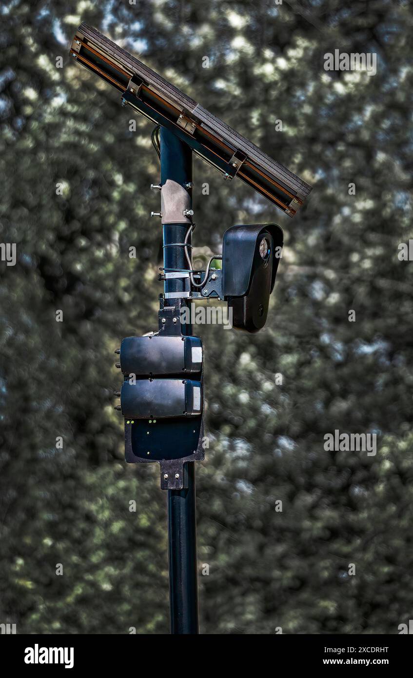 La caméra de reconnaissance de plaque d'immatriculation se fond dans l'arrière-plan. La caméra, montée sur un poteau noir, capture les données de plaque d'immatriculation des véhicules qui passent. Banque D'Images