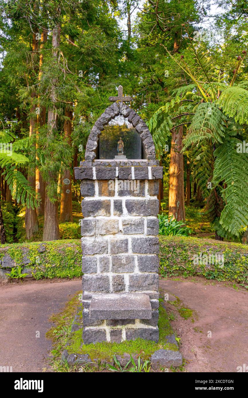 Monument religieux avec un saint dans un environnement paisible entouré d'arbres en fin d'après-midi dans le parc forestier des 7 Fontes. São Jorge Island-Azor Banque D'Images