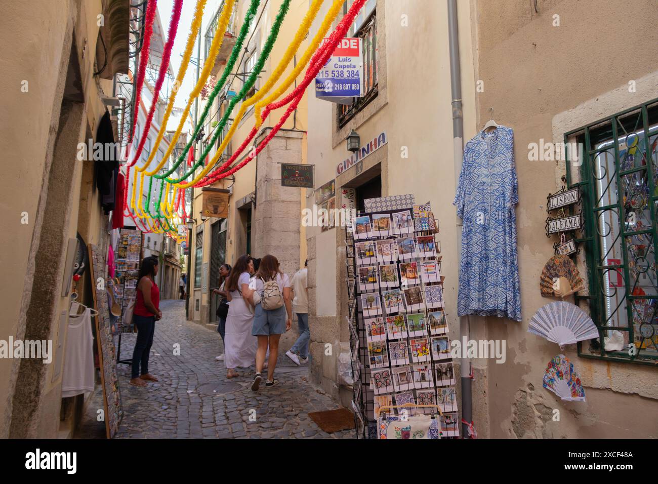 Les gens marchent dans une rue étroite du quartier Alfama à Lisbonne, Portugal, pendant les festivités populaires des Saints Banque D'Images