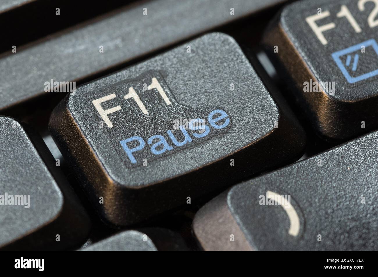 Macro, gros plan extrême détail d'une touche pause F11 sur un clavier d'ordinateur portable moderne, personne, pas de gens. Pause prendre une pause dans les activités de travail Banque D'Images