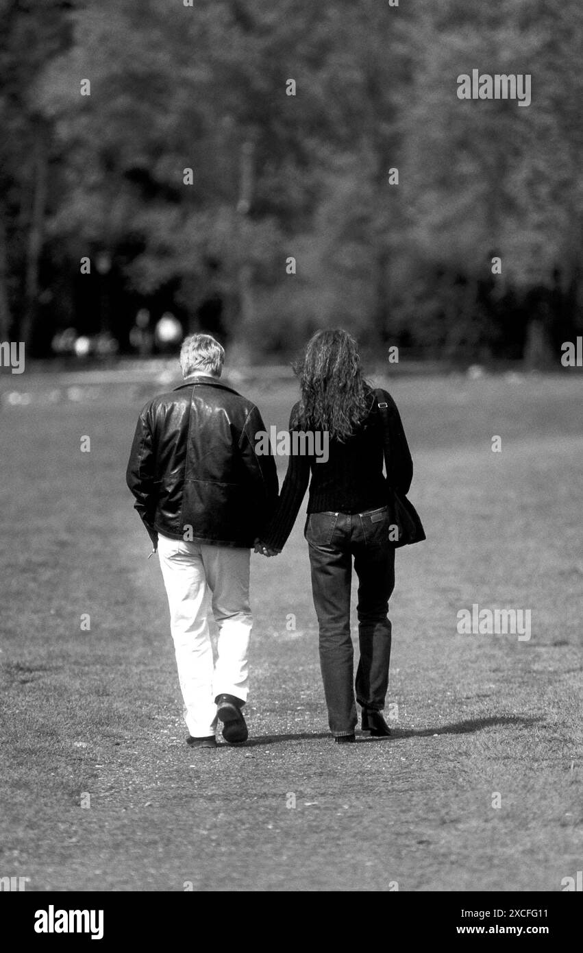 Couple tenant la main en marchant dans le jardin anglais, Munich, Allemagne, Europe Banque D'Images