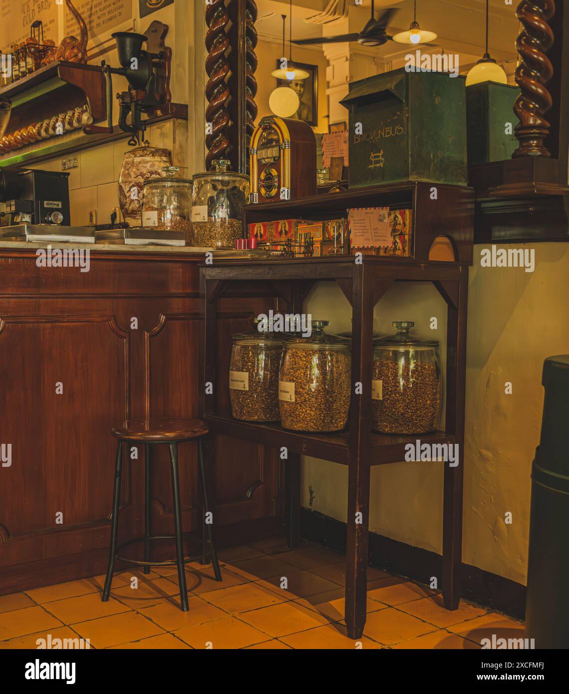 Jakarta Indonésie - 9 mai 2024. Une rangée de bocaux en verre pleins de divers grains de café avec des couvercles se trouve sur une étagère en bois altérée. Banque D'Images