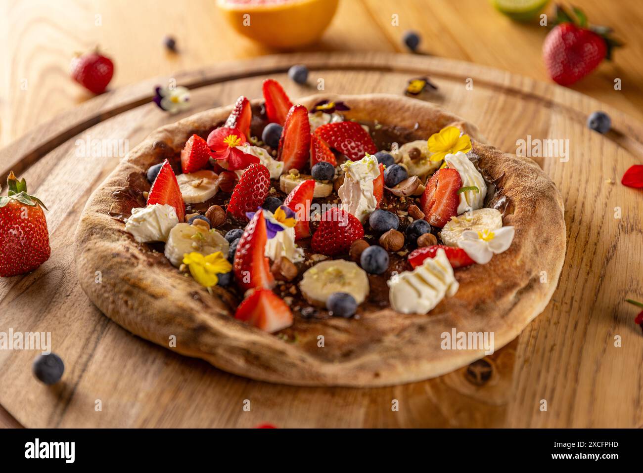 Pizza dessert gourmande sur table en bois, entourée d'ingrédients Banque D'Images