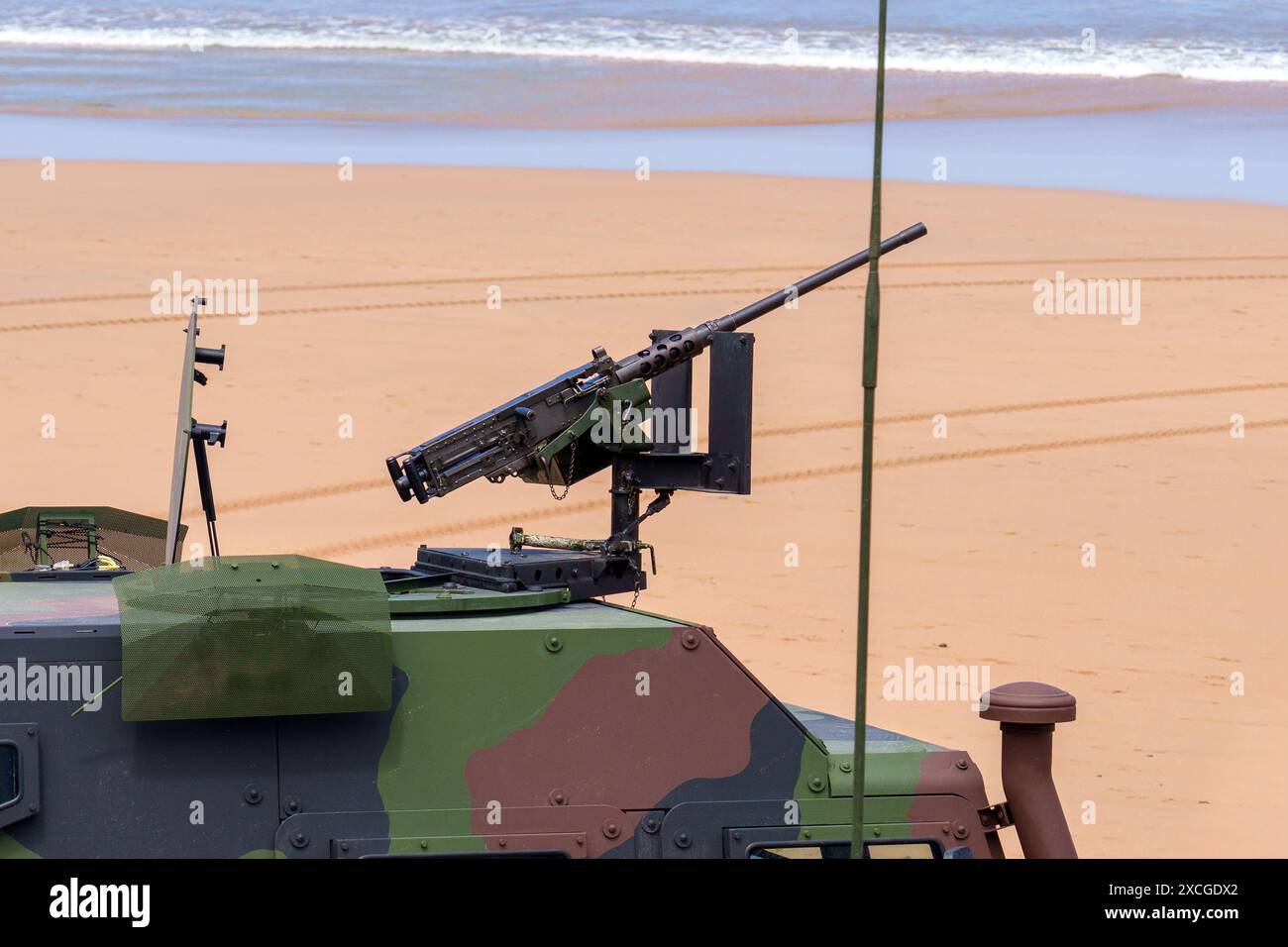 Véhicule blindé militaire de défense marine monté sur mitrailleuse lourde avec antennes et radars en couleur camouflage sur la plage de sable de près Banque D'Images